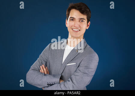 L'homme souriant avec bras croisés isolé sur fond bleu Banque D'Images