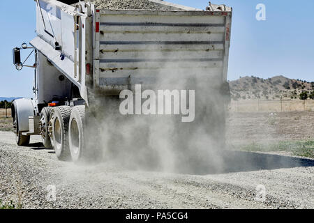 Un camion-benne répandre du gravier sur une allée de terre Banque D'Images