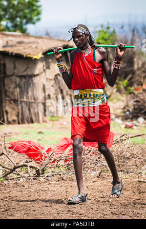 AMBOSELI, KENYA - 10 octobre 2009 : Unidentified Massai femme marche portant des vêtements rouge tribal typique et realiser un rocker pour l'eau au Kenya, Oct Banque D'Images