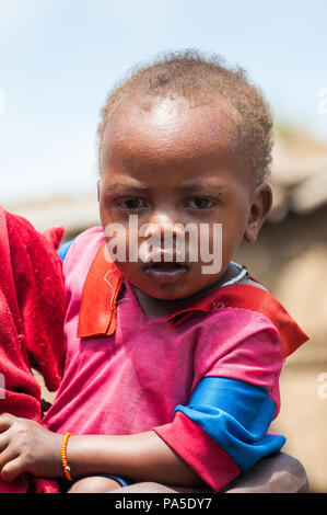 AMBOSELI, KENYA - 10 octobre 2009 : Portrait d'une petite fille Massai non identifié, serrant sa mère au Kenya, 10 Oct 2009. Les gens sont un Massai Nilotic Banque D'Images