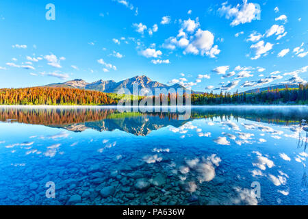 Lever de soleil sur lac Patricia dans le Parc National Jasper avec Pyramid Mountain en arrière-plan et brumeux brouillard sur la surface de l'eau. Eaux calmes se créer Banque D'Images