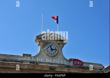 Les voyageurs français et les passagers voir cette horloge sur la façade avant de la gare de Béziers, France Banque D'Images
