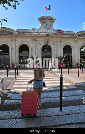 Jeune étudiant français avec valise rouge en arrivant à la gare de Béziers Banque D'Images