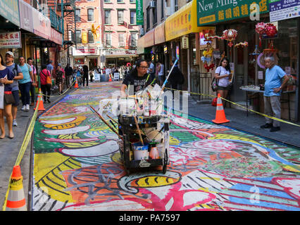 New York, New York City, USA. 20 juillet, 2018. Chen Dongfan rend dernière vérification pour son travail dans l'Doyers Street dans le quartier chinois de Manhattan, New York City, le 20 juillet 2018. Doyers Street, une zone de 200 mètres de long (61 mètres), en plein coeur de Chinatown, est recouvert d'une fresque vivante de l'artiste Chen Dongfan intitulé 'Le Chant des dragons et fleurs.' Dongfan travaille en partenariat avec l'Art Bridge et une partie de la NYC Department of Transportation's Doyers Street Rue saisonniers Public Art Program, ainsi que le partenariat Chinatown plaza piétonne de projet. Credit : Wang Ying/Xinhua/Alamy Live News Banque D'Images