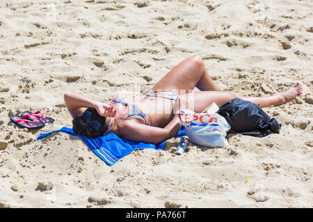 Bournemouth, Dorset, UK. 21 juillet 2018. UK : météo chaude et ensoleillée à Bournemouth plages, comme chef de la mer sunseekers pour profiter du soleil au début des vacances d'été. femme en train de bronzer sur la plage. Credit : Carolyn Jenkins/Alamy Live News Banque D'Images