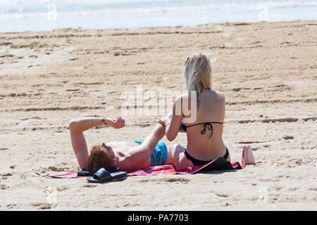 Bournemouth, Dorset, UK. 21 juillet 2018. UK : météo chaude et ensoleillée à Bournemouth plages, comme chef de la mer sunseekers pour profiter du soleil au début des vacances d'été. Couple de bronzer sur une violation. Credit : Carolyn Jenkins/Alamy Live News Banque D'Images