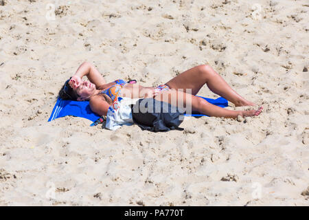 Bournemouth, Dorset, UK. 21 juillet 2018. UK : météo chaude et ensoleillée à Bournemouth plages, comme chef de la mer sunseekers pour profiter du soleil au début des vacances d'été. Femme en train de bronzer sur la plage. Credit : Carolyn Jenkins/Alamy Live News Banque D'Images