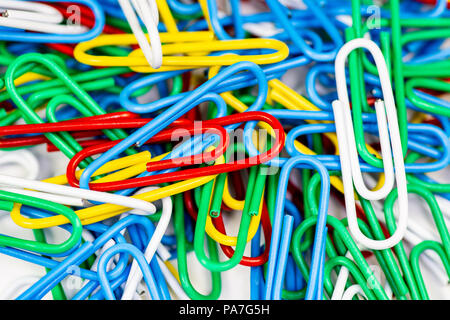 Trombones colorés en paquets sur une surface blanche. Banque D'Images