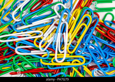 Trombones colorés en paquets sur une surface blanche. Banque D'Images