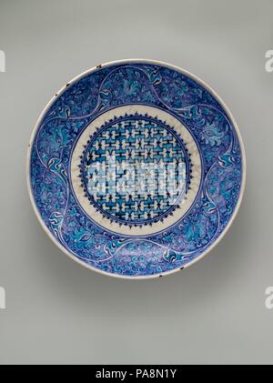 Le plat. Dimensions : H. 3. (7,62 cm) Diam. 15 1/2 po. (39,4 cm). Date : milieu du 16e siècle. L'un des plus spectaculaires d'Iznik pièces dans la collection du Musée, ce plat en forme de soucoupe affiche une palette de bleu turquoise brillant et riche caractéristique de la céramique Iznik précoce. Le floral défile sur l'cavetto sont inspirés par le quinzième siècle celadon chinois ware. Musée : Metropolitan Museum of Art, New York, USA. Banque D'Images