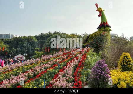 Le coq fait à partir de fleurs fraîches colorées, la décoration du Nouvel An chinois à l'intérieur du parc de la ville. Banque D'Images