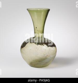 Bouteille en verre. Culture : Roman. Dimensions : H. 7 1/8 in. (18,1 cm). Date : 4ème-5ème siècle de notre ère. La lumière translucide vert. D'épaisseur inégale, rim, fissurés et sol, en entonnoir ; cou-épaule légèrement poussé en extérieur, avec la crête horizontale ; vaste corps globulaire, ; fond concave. Corps décoré de nombreuses côtes, s'étendant dans une spirale régulière de gauche à droite à partir de ci-dessous sur la crête de l'épaule, de plus en plus pâle, et disparaissant sur partie inférieure de côté. Intacts ; beaucoup de piqûre et quelques grosses bulles, et soufflant de stries, avec un noir inclusion dans le cou ; légère iridescence sur l'extérieur, la Banque D'Images