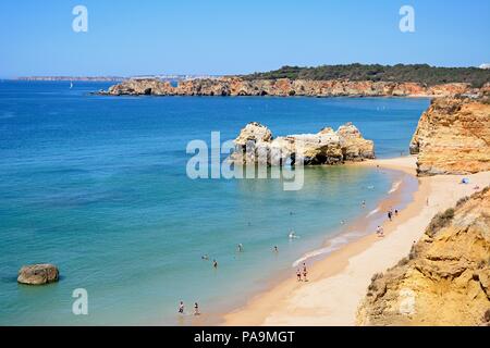 Portrait de la côte rocheuse avec des touristes de détente sur la plage de sable de Praia da Rocha, Algarve, Portugal, Europe. Banque D'Images