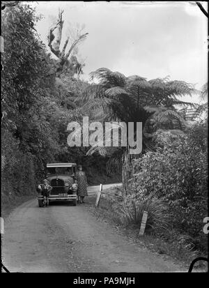 177 Motor car avec l'épouse de Albert Percy Godber, Laura Godber, et l'un de ses petits-fils debout devant une voiture garée sur un virage sur la route Akatarawa, vers la fin des années 1930 ou au début des années 1940 ATLIB 308051 Banque D'Images