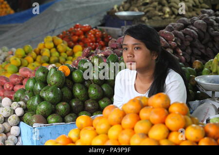 Une marchande de fruits et légumes à un marché de village en Indonésie Banque D'Images