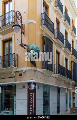 Escargot de bronze sculpture courir vers le haut le côté d'un immeuble dans le vieux quartier de Séville Banque D'Images