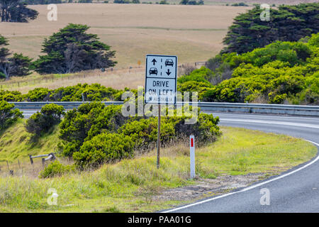 Signe de route sur la Great Ocean Road, rappelant aux automobilistes de conduire sur la gauche, de l'Australie. Banque D'Images