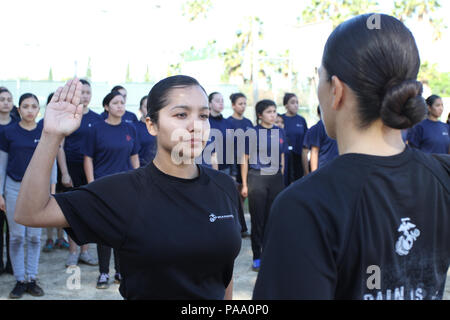 Un Marine se réengage pour quatre années supplémentaires lors d'une réunion de piscine féminine au Sherman Oaks Recreation Park, Van Nuys, Californie. L'événement est organisé par Recruiting Station Los Angeles pour engager les poolees et promouvoir le recrutement du corps des Marines. Les instructeurs supervisent les formations, imposent la discipline et effectuent des tests de force initiaux. L'événement Marine corps met l'accent sur la condition physique, le développement professionnel, le travail d'équipe et la préparation au service. Les Poolees reçoivent une formation sur les normes uniformes, la préparation de la formation de base et les attentes opérationnelles. Banque D'Images