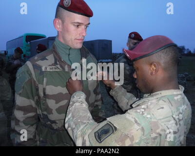 U.S. Army paratrooper PFC. Justin Albert, affecté à la 173e Brigade aéroportée, les broches le parachutiste américain sur un insigne de parachutiste français, le 15 mars 2016, dans le cadre de l'échange d'aile à la suite du succès d'une opération aéroportée sur Frida Drop Zone près de la base d'Aviano, en Italie. La 173e Brigade aéroportée de parachutistes français l'hôte de la 11e brigade parachutiste de l'artillerie du 35e Régiment de parachutistes d'augmenter la compétence et l'interopérabilité dans les opérations aéroportées combinées. (U.S. Photo de l'armée par le Sgt. Jason Hackworth) Banque D'Images