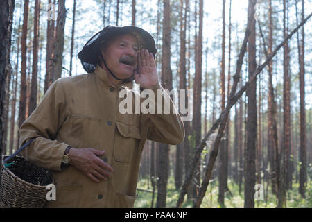 Où êtes-vous concept. L'homme mature habillé de vieux vêtements holding basket est perdu en forêt. Il crie son ami essayant de le trouver Banque D'Images