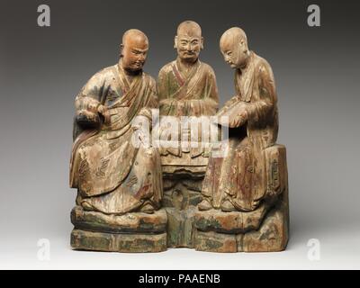 Trois Arhats (Luohans). Culture : la Chine. Dimensions : H. 22 1/4 in. (56,5 cm) ; W. 22 in. (55,9 cm) ; D. 7. (17,8 cm). Date : 16ème-17ème siècle. Avec la propagation du bouddhisme Chan (Zen) en Chine au 10e siècle, louhans, bouddhiste éclairé sages, étaient souvent représentés comme moines effectuant des exercices spirituels. Assis sur des rochers grossièrement taillé, ces trois louhans sont engagés dans l'étude et à la méditation. Leurs robes étaient à l'origine et de couleur doré sur un sol de gesso. Sculpté dans un seul morceau de bois, les trois chiffres sont probablement partie d'un grand rassemblement. Musée : Metropolitan Museum of Art, New Banque D'Images