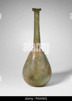 Bouteille en verre. Culture : Roman. Dimensions : H. : 9 5/16 in. (23,6 cm). Date : 1er-début 2e siècle de notre ère. Bleu pâle translucide vert. Rim à collier, dépliées, bas, rond, et, avec la lèvre extérieure arrondie verticale ; grande, mince, le cou cylindrique, l'extension vers le bas et horizontalement en usiné autour de base ; corps piriforme ; fond concave. Intacts ; peu de bulles ; une certaine surface de piqûres et de l'éraflure, ternissement brun crémeux, intempéries, et irisés. Musée : Metropolitan Museum of Art, New York, USA. Banque D'Images