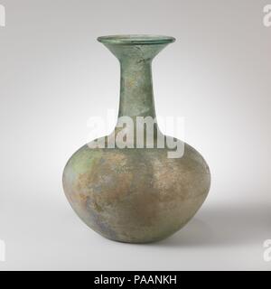 Bouteille en verre. Culture : Roman. Dimensions : H. : 9 7/16 in. (24 cm). Date : 4ème-5ème siècle de notre ère. Bleu translucide vert. Jante tubulaire éversée, repliées et en forme d'entonnoir ; en bouche ; cou cylindrique, l'extension vers le bas ; vaste mais corps trapu avec diamètre maximum au-dessus du point médian ; fond concave. Cassé et réparé sur un côté de la jante et de la bouche ; et le soufflage des bulles piqûre ; stries, piqûres et ternir l'altération irisé. Musée : Metropolitan Museum of Art, New York, USA. Banque D'Images