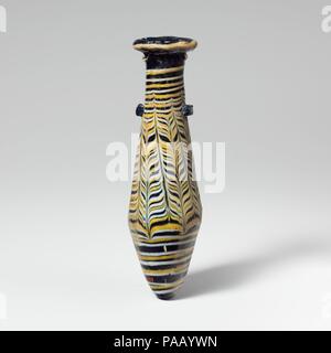 Alabastron en verre (flacon de parfum). Culture : le grec, l'Est de la Méditerranée. Dimensions : H. : 5 1/16 in. (12,9 cm) Diam. : 1 7/16 x 1 1/4 in. (3,6 x 3,1 cm). Date : 2e-1e siècle av. J.-C.. Bleu translucide, avec poignées de même couleur ; sentiers en jaune opaque et blanc opaque. Jante large-dur, irrégulier, et en pente vers l'intérieur avec des marques d'outillage rayonnant sur les surfaces supérieure et inférieure, et jagged, projetant la lèvre intérieure de cou cou cylindrique ; rectiligne ; corps fusiforme, puis vers le bas en expansion en effilant à fond pointu ; deux poignées patte horizontale allongée appliquée au haut de corps au fil des sentiers, l'marvered b Banque D'Images