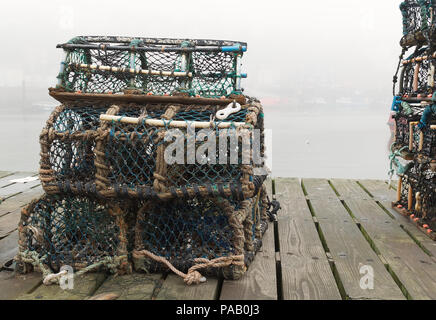 Des casiers à homard sur le port de Whitby, North Yorkshire, Angleterre avec la brume sur la mer bateaux dans l'arrière-plan. Profondeur de champ. Concept de pêche Banque D'Images