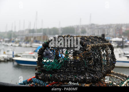 Des casiers à homard sur le port de Whitby, North Yorkshire, Angleterre avec la brume sur la mer bateaux dans l'arrière-plan. Profondeur de champ. Concept de pêche Banque D'Images