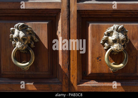 Tête de Lion en bronze heurtoirs de porte sur une porte en bois à Rome Banque D'Images