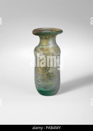 Bouteille en verre. Culture : Roman. Dimensions : H. 3. (7,6 cm). Date : 1er et 2e siècle de notre ère. Verdâtre Translucide bleu. Jante large, dépliées, ronde, et dans la bouche de torchage ; ; ; cou concave oblique ; corps cylindrique avec presque droit, côtés verticaux ; épaisses, aplatie en bas avec pontil circulaire cicatrice. Intacts ; quelques bulles et des stries de soufflage ; des piqûres et iridescence sur l'extérieur, avec incrustations pierreuses épais sous rim, des taches de l'émail noir-comme l'incrustation sur l'altération et certains de l'intérieur. Musée : Metropolitan Museum of Art, New York, USA. Banque D'Images