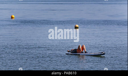 Un homme jouit du beau temps sur la plage de Whitstable, Kent, comme le temps chaud se poursuit. Banque D'Images