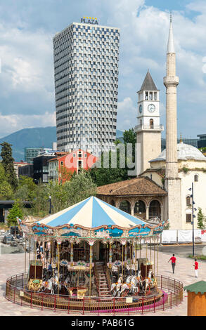 Un carrousel pour enfants dans la place Skanderbeg, avec la mosquée Et'hem Bey, la tour de l'horloge et la Plaza Hotel en arrière-plan, Tirana, Albanie, Banque D'Images