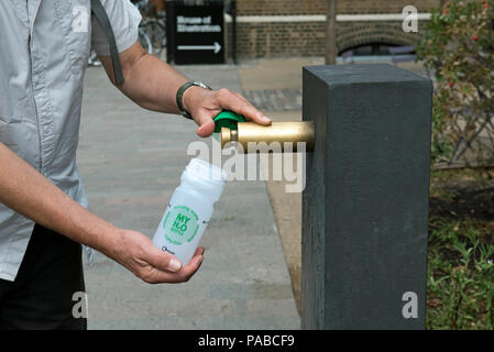 Man filling bouteille d'eau réutilisable à partir de la fontaine d'eau moderne, Kings Cross, Camden, London England Angleterre UK Banque D'Images