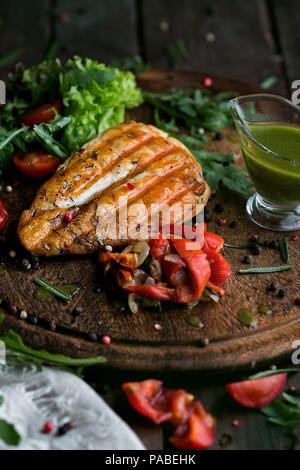 Savoureux et juteux Steak de poulet sur une plaque de bois. Banque D'Images