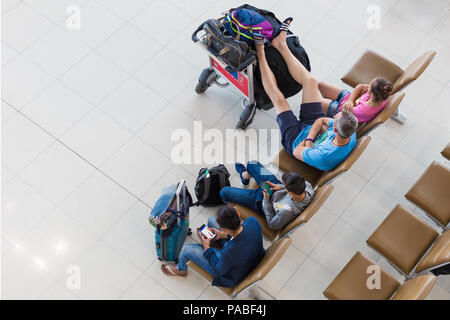 BANGKOK, THAÏLANDE - 21 juillet 2018 - Quatre touristes passant d'attente pour les vols avec certains utilisent leurs appareils mobiles à l'International Suvarnaphumi Airp Banque D'Images