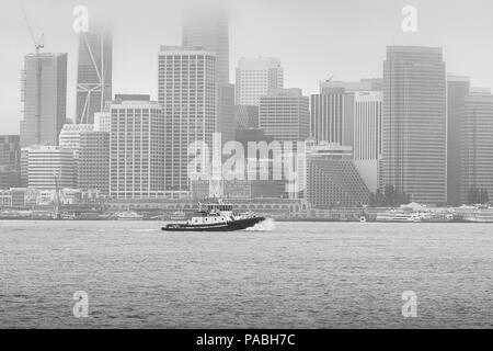 Photo en noir et blanc du Tugboat DELTA D'Oakland BLEU, en passant la Skyline de San Francisco. Banque D'Images