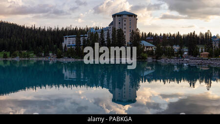 Vue dans un lac glaciaire entouré de montagnes Rocheuses du Canada au cours d'un lever du soleil vibrant. Prises à Lake Louise, Banff, Alberta, Canada. Banque D'Images