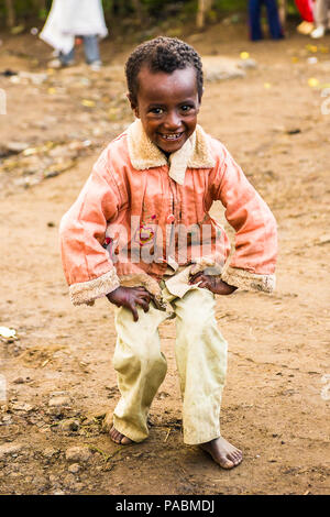 LALIBELA, ÉTHIOPIE - le 28 septembre 2011 : petit garçon éthiopien non identifiés pour l'appareil photo des danses portant chemise rose et un pantalon blanc. Les gens de l'Eth Banque D'Images