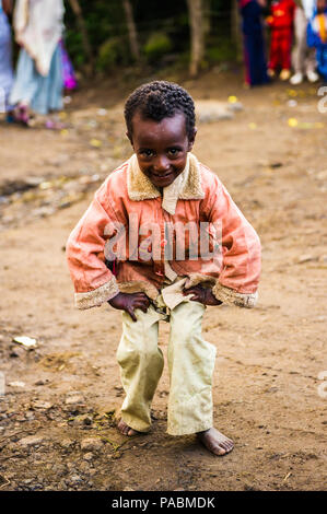 LALIBELA, ÉTHIOPIE - le 28 septembre 2011 : petit garçon éthiopien non identifiés pour l'appareil photo des danses portant chemise rose et un pantalon blanc. Les gens de l'Ethi Banque D'Images