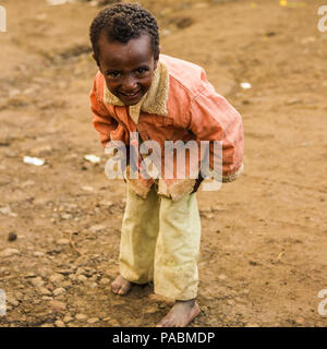 LALIBELA, ÉTHIOPIE - le 28 septembre 2011 : petit garçon éthiopien non identifiés pour l'appareil photo des danses portant chemise rose et un pantalon blanc. Les gens de l'Ethi Banque D'Images