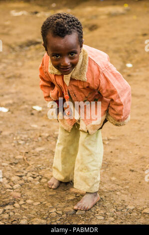 LALIBELA, ÉTHIOPIE - le 28 septembre 2011 : petit garçon éthiopien non identifiés pour l'appareil photo des danses portant chemise rose et un pantalon blanc. Les gens de l'Eth Banque D'Images