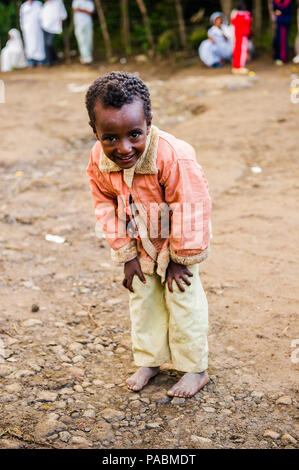 LALIBELA, ÉTHIOPIE - le 28 septembre 2011 : petit garçon éthiopien non identifiés pour l'appareil photo des danses portant chemise rose et un pantalon blanc. Les gens de l'Ethi Banque D'Images