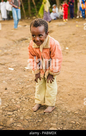 LALIBELA, ÉTHIOPIE - le 28 septembre 2011 : petit garçon éthiopien non identifiés pour l'appareil photo des danses portant chemise rose et un pantalon blanc. Les gens de l'Ethi Banque D'Images