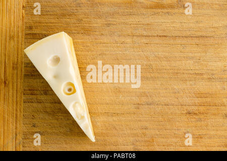 Bonne partie de plats Néerlandais fromage Maasdam riche en calcium disposés comme une frontière latérale sur une vieille carte de bambou avec copie espace vue libre fr Banque D'Images