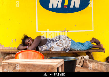 ACCRA, GHANA - mars 4, 2012 : Unidentified femme ghanéenne dort sur un banc dans la rue au Ghana. Les gens souffrent de la pauvreté du Ghana en raison de l'unsta Banque D'Images