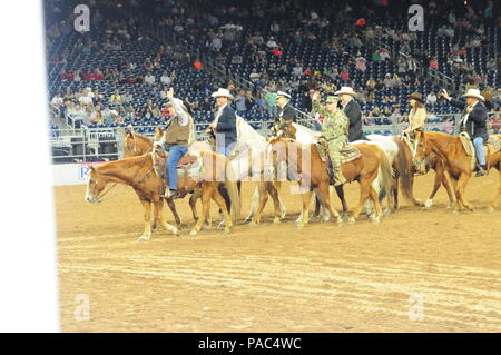 Le brig. Le général Rodney Fogg (centre), commandant de la 13e Commandement de soutien expéditionnaire et III Corps commandant général adjoint pour l'appui, des vagues à la foule lors de la Grande Entrée, le 2 mars, à la Houston Livestock Show and Rodeo. Plus de 2 000 militaires et leurs familles ont été fournis gratuitement l'entrée au parc et un déjeuner barbecue avant de regarder le rodéo et les Chris Young Concert. (Photo par le Major Joe Odorizzi, officier des affaires publiques de la 13e ESC) Banque D'Images