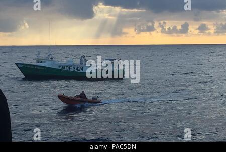 L'équipe d'arraisonnement du le USCGC Galveston Island (WPB 1349), homeported à Honolulu, retourne à bord d'un petit bateau à partir de la 71 pieds de bateau de pêche commercial Lady Ann Margaret pour un embarquement de la pêche plus de 350 milles au large de Oahu à l'appui de la Garde côtière en stratégie Ocean Guardian, 4, mars 2016. Lors d'une patrouille avec un NOAA National Marine Fisheries, agent à bord, l'équipage a effectué neuf arraisonnements conjoints résultant en deux cas documentés de la pêche illégale. (U.S. Photo de la Garde côtière par Seaman Calsea Clemens/libérés) Banque D'Images