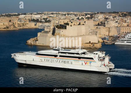 Le catamaran Jean de La Valette au départ de Malte, en route vers la Sicile, avec le Fort St Angelo dans l'arrière-plan. Transport par mer dans l'UE. Banque D'Images